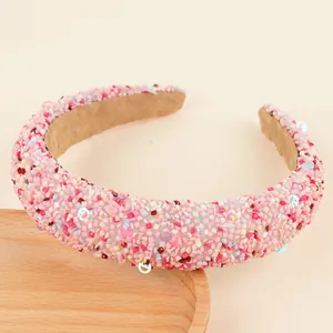 Gros plan détaillé d'un serre-tête rose épais avec strass colorés et paillettes smiley