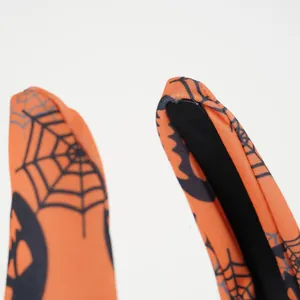 Detail of Halloween headband showing orange spider web fabric and stitching craftsmanship