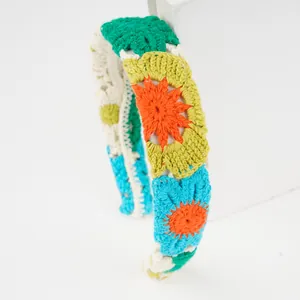 Detailed view of hand-knitted floral headband with colorful crochet petal patterns
