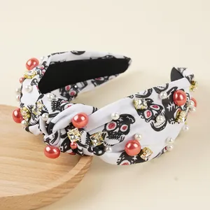 Knotted Halloween headband with rhinestones, pearls, and skull patterns on white fabric