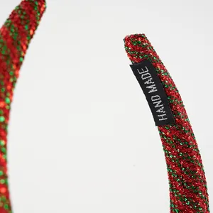 Detail eines glitzernden Weihnachts-Haarreifs mit roten und grünen Pailletten-Details