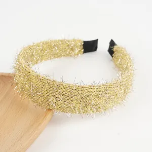 Detail of glitter gold knitted headband showing textured fabric and black end tips