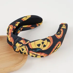 Halloween knot headband featuring orange pumpkin prints on black fabric for party wear