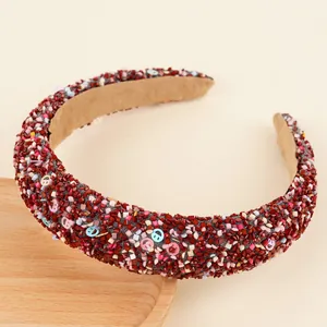 Détail du serre-tête éponge marron-rouge avec sequins smiley colorés et texture perlée