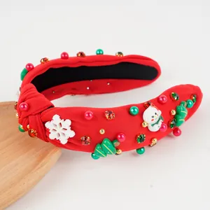 Détail d'un serre-tête de Noël rouge avec perles, strass et décorations festives