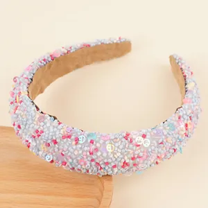 Détails de perles colorées et de paillettes smiley sur un serre-tête rembourré