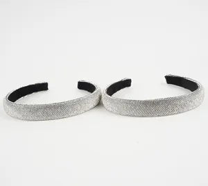 Close-up of sparkling silver rhinestone headband with black velvet lining detail