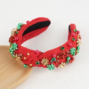 Detail of red knotted headband with festive beads, pearls and star ornaments