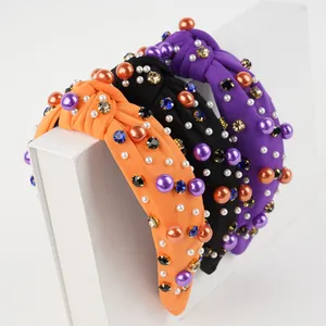 Close-up of knotted velvet headbands with shiny pearls and colorful rhinestones