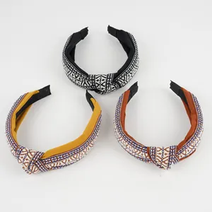 Close-up of wide knotted headbands featuring vintage embroidery and geometric patterns