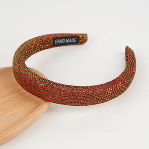 Detail eines rot-grünen gepolsterten Stirnbandes mit Glitzer und Hand Made-Etikett