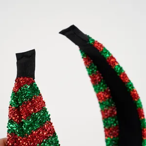 Nahaufnahme von glitzerndem rotem und grünem Lametta auf einem geknoteten Weihnachts-Haarreif