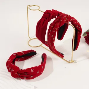 Detail of red velvet headbands with gold heart prints and bows on a display stand