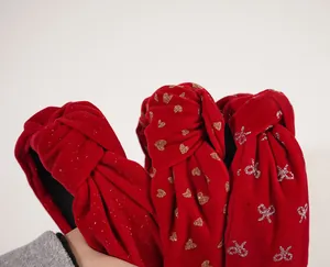 Detailed close-up of red velvet knotted headbands with gold sequins and festive bow patterns