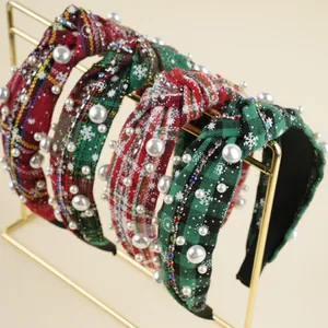 Close-up of knotted Christmas headbands with red plaid, pearls, and snowflake details