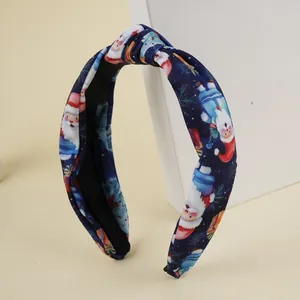 Détail du serre-tête croisé avec imprimé festif du Père Noël et flocons de neige