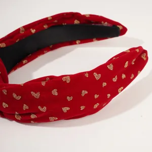 Red velvet New Year headband with golden heart patterns and a festive knotted bow