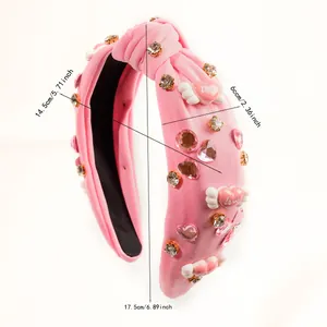 Detalle de diadema rosa con alas Love, corazones de resina y brillantes pedrería