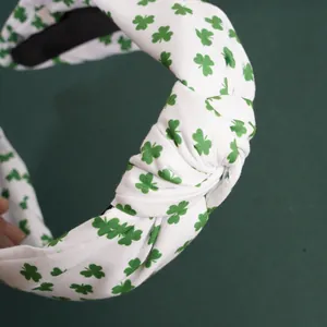 Détail du serre-tête noué pour la Saint-Patrick avec trèfles verts sur tissu blanc doux
