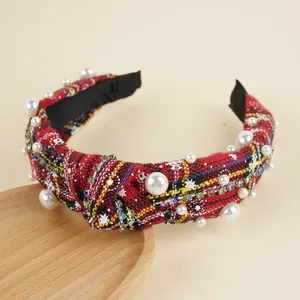 Detail of red plaid headband featuring white pearls, colorful rhinestones, and knotted design