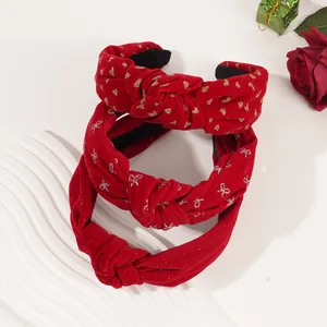 Close-up of red velvet headbands with gold heart and bow prints for festive styling