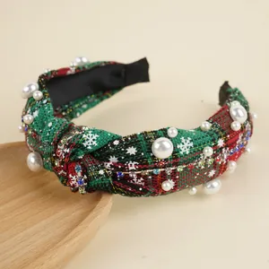 Close-up of Christmas knotted headband with red plaid fabric, pearls and rhinestones