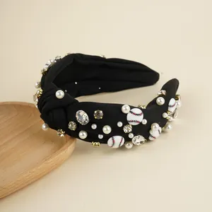 Close-up of black knotted headband with white pearls, rhinestones and baseball charm