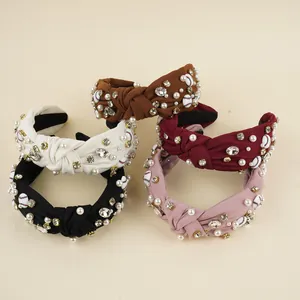 Close-up of knotted fabric headbands with pearls, rhinestones and baseball charms