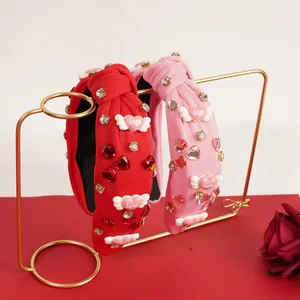 Detalle de diademas rojas y rosas con corazones de strass y alas de ángel Love