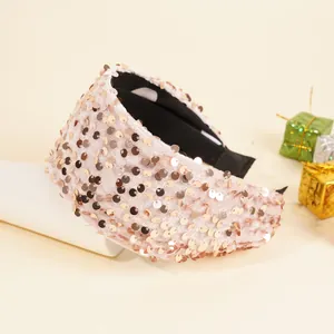 Detail showing the shiny pink sequins texture and black inner lining of the wide headband