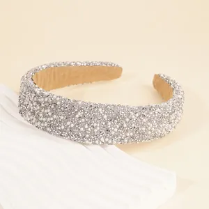 Close-up of wide headband featuring shimmering silver rhinestones and white pearls detail