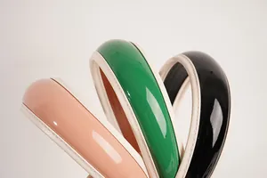 Dettaglio di cerchietti imbottiti in pelle PU rosa, verde e nera con cuciture beige