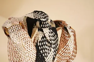 Detail of bohemian raffia headband showing intricate cross-weave texture and amber ring buckle