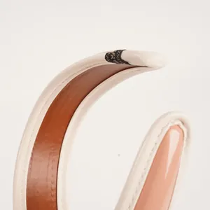 Dettaglio del cerchietto minimalista in pelle PU con cuciture di pregio e bicolore