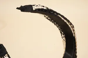 Close-up of bohemian woven raffia headband showing black and white crisscross texture
