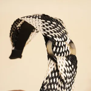 Macro detail of Bohemian woven raffia headband with black and white texture and resin ring