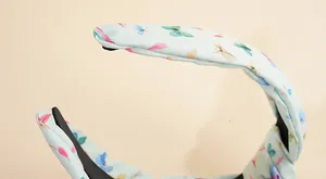 Detailaufnahme des floralen Schmetterlingsmusters und der Nahtkanten am Stoff-Stirnband