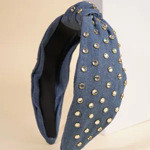Detail of blue denim knotted headband with sparkling rhinestones in gold settings