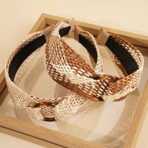 Detail of bohemian raffia wide headbands with resin rings on a wooden tray