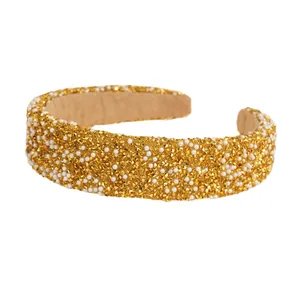 Sparkling wide headband with gold rhinestones and white pearls on a soft base