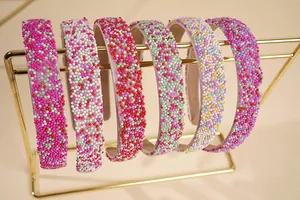 Detail of colorful bead embellishments on padded headbands on a gold metal display