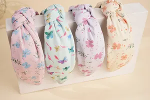Detailansicht von vier geblümten Haarbändern mit Knoten in Rosa, Blau, Violett und Beige