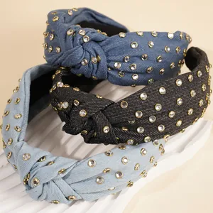 Detailed view of three knotted denim headbands with sparkling rhinestones in assorted colors
