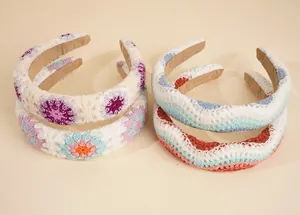Detail of four colorful knit headbands featuring floral and wavy crochet patterns