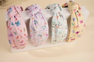 Nahaufnahme von vier geblümten Haarbändern in Rosa, Lila, Minzgrün und Gelb mit Knoten