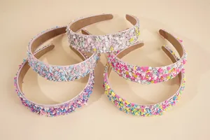 Detail von fünf bonbonfarbenen Stirnbändern mit eingelegten Perlen, Strass und Herzpailletten