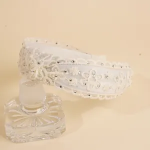 Detail van een brede kanten geborduurde haarband met glanzende strass-steentjes voor dames