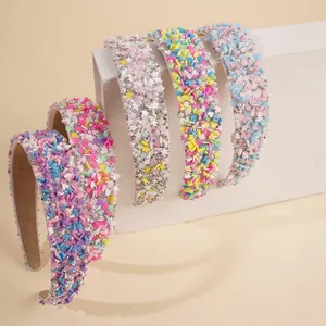 Detail von fünf bonbonfarbenen Stirnbändern mit Strass, Perlen und Herzdekorationen