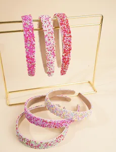 Detail shot of a six-piece set of colorful beaded headbands on a gold metal display stand