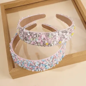 Detail von bonbonfarbenen Stirnbändern mit Strass, Perlen und Sternen auf Satinbasis